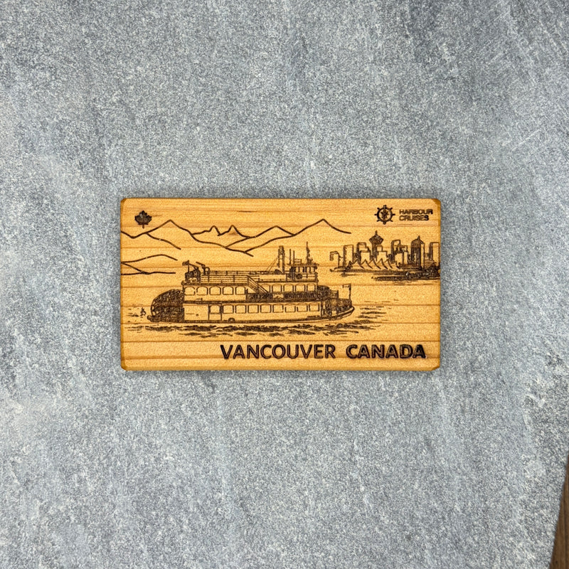 Wooden magnet with engraved image of a steamboat and text 'Vancouver Canada' on a gray surface