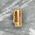 Wooden souvenir magnet with a tree design and 'Vancouver Canada' text on a stone surface