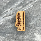 Wooden souvenir magnet with a tree design and 'Vancouver Canada' text on a stone surface