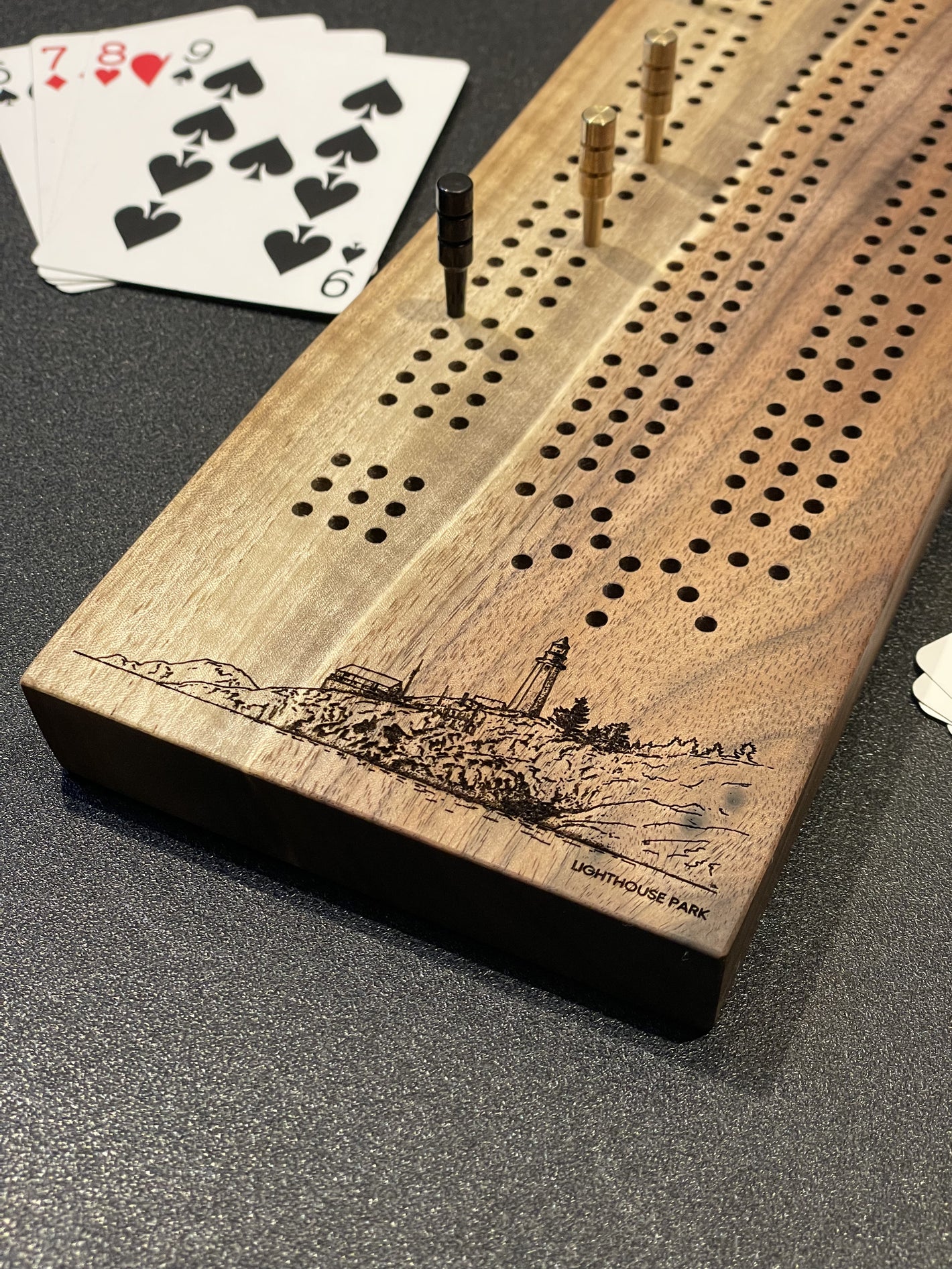 Walnut cribbage board engraved with Lighthouse Park, paired with high quality metal pegs. You can find this at Makers in Lonsdale and on www.tundra-designs.com.